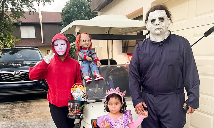 A family photo taken in front of the golf cart on Halloween