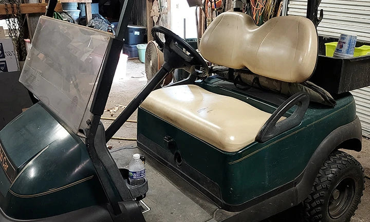 A golf cart is about to have its battery replaced.