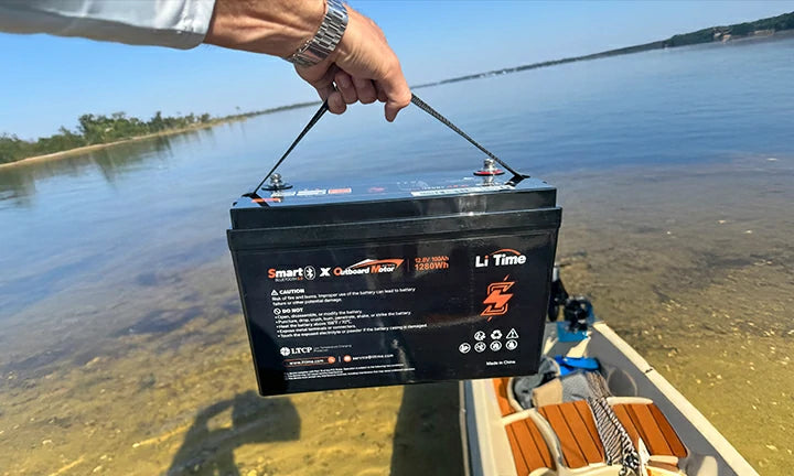 a man holding a litime 12V 100Ah bluetooth trolling motor battery showing its lightweight