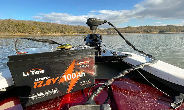 A LiTime battery powering a trolling motor on the bow of a bass boat on a beautiful, sunny lake