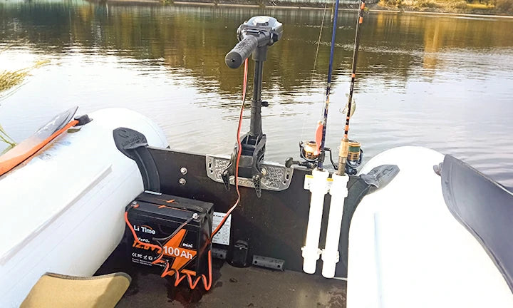 The view towards the back of a small boat, showing a LiTime battery powering the trolling motor