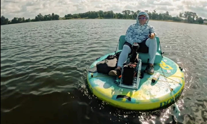 A man peacefully fishes from an inflatable boat powered by a LiTime trolling motor battery on a calm lake