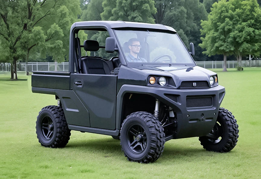 A man driving a black utility golf cart on a grassy field, highlighting features for golf cart lithium batteries.