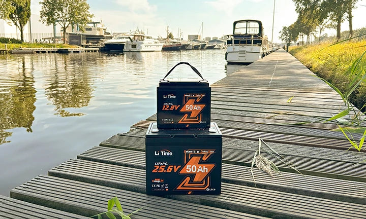 2 LiTime 50ah trolling motor batteries stacked on a peaceful dock in a marina, ready for boating season
