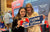 young fans at LiTime's Bass Master booth, holding 'I LOVE LiTime' and heart-shaped brand mascot signs