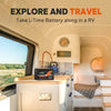A LiTime 100ah battery sits on the kitchen counter inside a cozy, modern camper van, ready for travel.